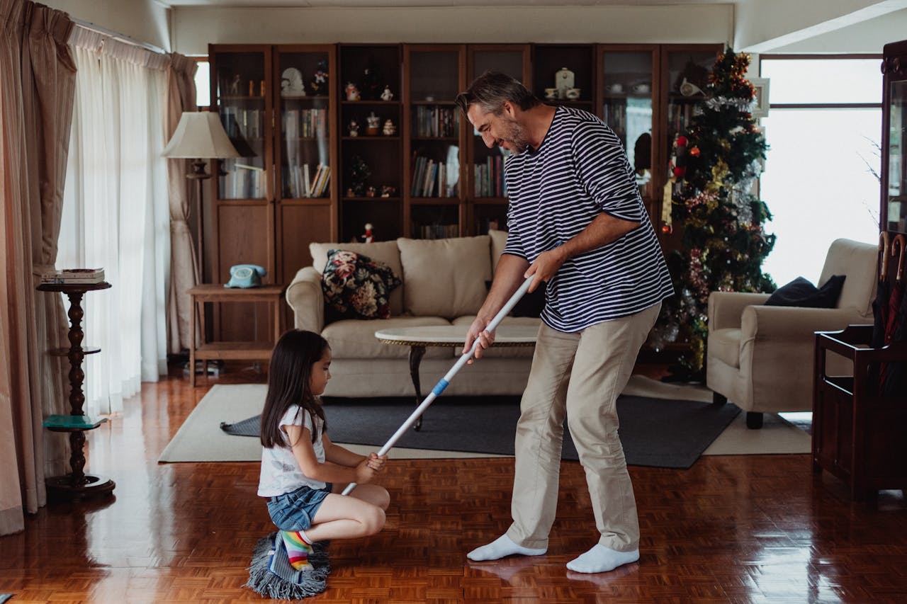 why-choose-us Father and daughter having fun mopping the living room floor together, creating joyful memories.